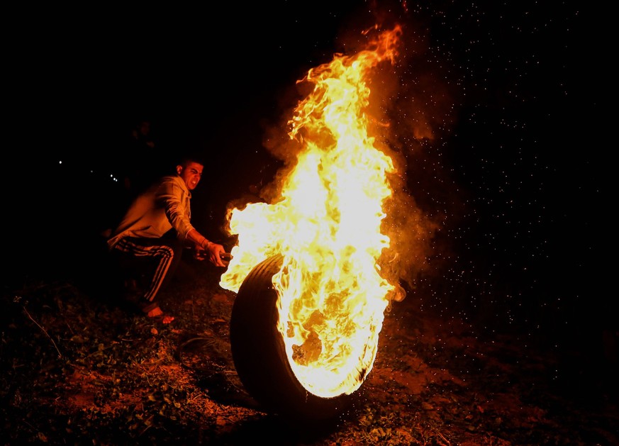 February 27, 2023, Gaza, Palestine: Gaza, Palestine. 27 February 2023. Palestinians burn tires during a night demonstration along the Israel-Gaza border in the southern Gaza Strip, in protest against  ...