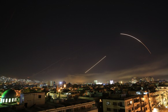 Missiles streak across the Damascus skyline as the U.S. launches an attack on Syria targeting different parts of the capital, early Saturday, April 14, 2018. Syria's capital has been rocked by loud ex ...