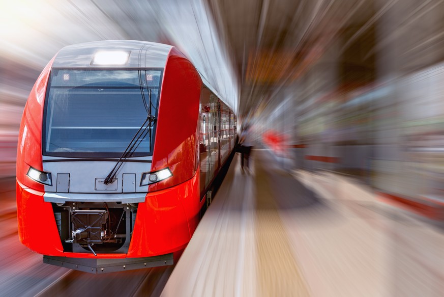 Modern high-speed train moves fast along the platform.