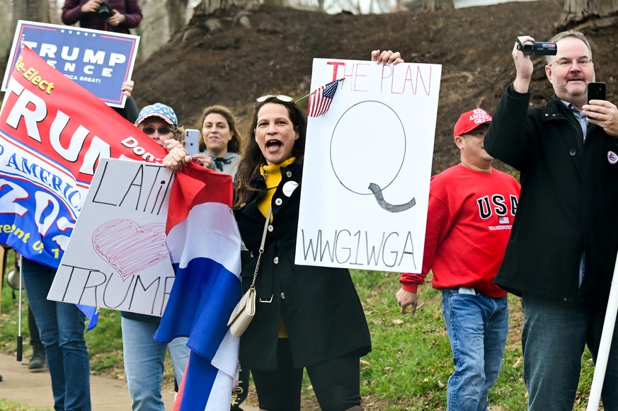 Eine Trump-Supporterin trägt ein Schild mit dem Buchstaben Q, der sich auf QAnon bezieht.