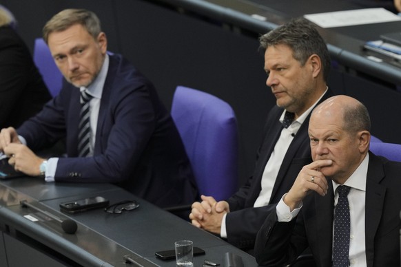 FILE - German Chancellor Olaf Scholz, right, Economy and Climate Minister Robert Habeck and Finance Minister Christian Lindner, left, listen to a debate about Germany&#039;s budget crisis at the parli ...