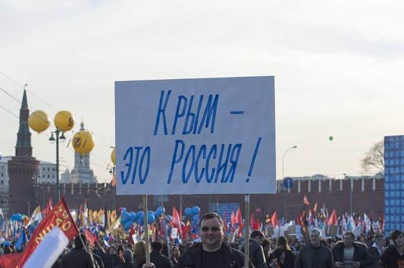 Die Krim gehört zu Russland steht auf dem Plakat des Mannes auf einer Veranstaltung 2015 in Moskau.