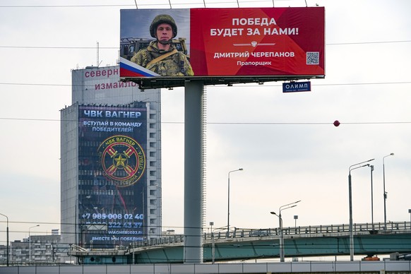 28.03.2023, Russland, Moskau: An der Fassade eines Gebäudes ist ein Werbeschild zu sehen, auf dem für das Militärunternehmen Wagner (hinten) geworben wird und auf dem zu lesen ist «Schließen Sie sich  ...