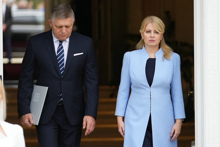 25.10.2023, Slowakei, Bratislava: Zuzana Caputova (r), Präsidentin der Slowakei, und Robert Fico, neu ernannter Ministerpräsident der Slowakei, stellen sich nach der Vereidigungszeremonie im Präsident ...