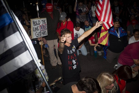 Syndication: Arizona Republic Supporters of President Donald Trump pray at a protest outside of the Maricopa County Elections Department as ballots are counted for the 2020 election in Phoenix on Nov. ...