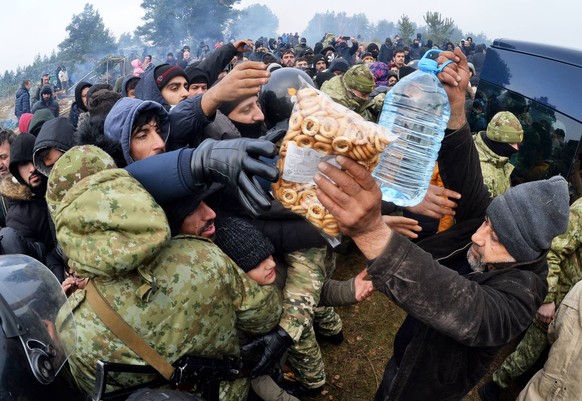 Belarus Poland Border Refugees 6692907 10.11.2021 Refugees receive humanitarian aid from the Belarusian Red Cross at a migrant camp on the Belarusian-Polish border in Grodno region, Belarus. Migrants  ...