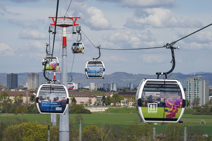 14.04.2023, Baden-Württemberg, Mannheim: Besucher fahren beim Start der Bundesgartenschau mit der eigens gebauten Seilbahn. Nach 1975 ist Mannheim zum zweiten Mal Ausrichter der Buga. Bis zum 8. Oktob ...