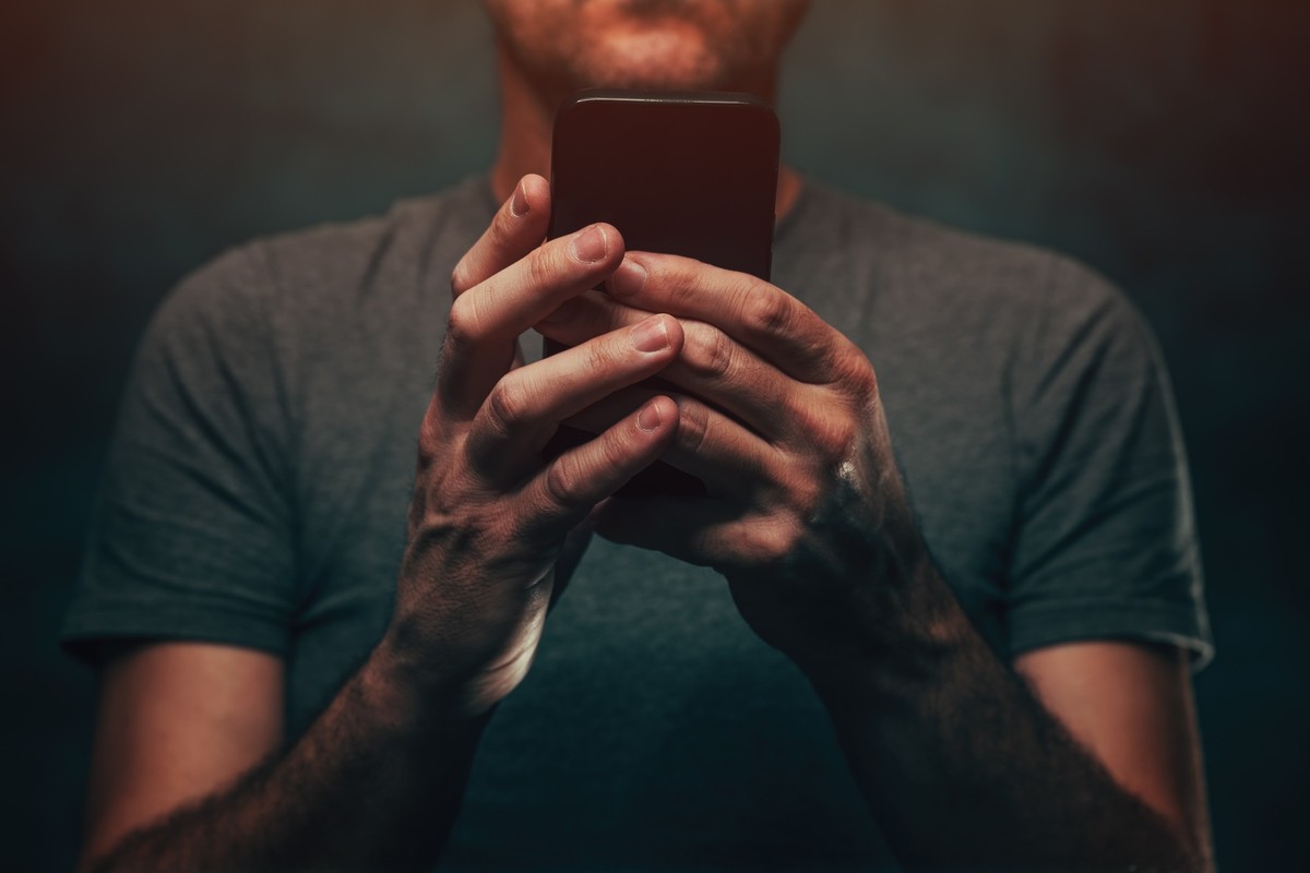 Man consuming online content on smartphone device, selective focus