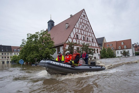 GRIMMA, GERMANY - JUNE 03: Firefighters and helpers evacuate inhabitants in the flooded city center on June 3, 2013 in Grimma, Germany. Heavy rains are pounding southern and eastern Germany, causing w ...
