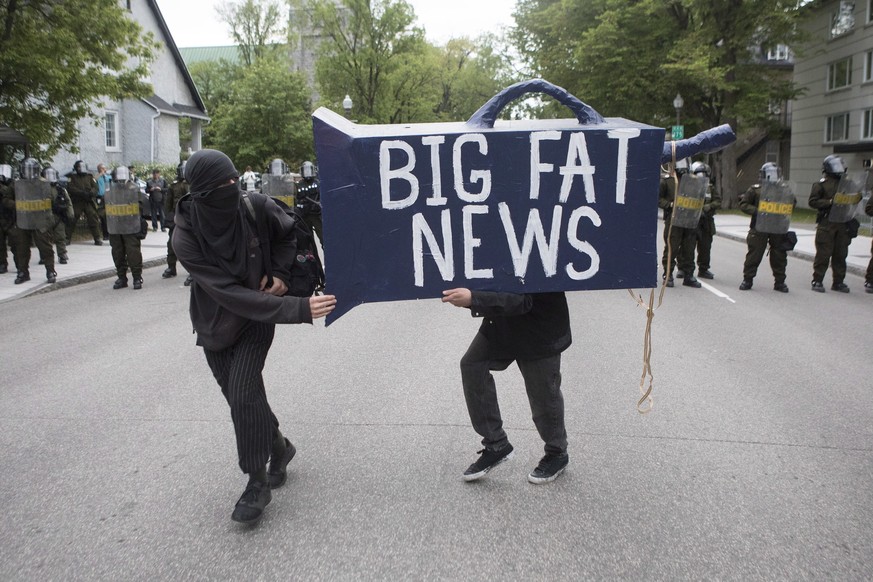 Protesters run past a line of police during an anti-G7 demonstration in Quebec City on Thursday, June 7, 2018, ahead of the start of the G7 Summit. (Chris Young/The Canadian Press via AP)