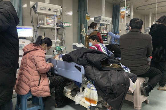 23.12.2022, China, Bazhou: Angehörige versammeln sich in der Notaufnahme des Langfang No. 4 People&#039;s Hospital in der Stadt Bazhou in der nordchinesischen Provinz Hebei neben den Betten der erkran ...