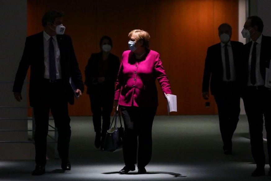 BERLIN, GERMANY - MARCH 03: German Chancellor Angela Merkel (C), Bavarian Premier Markus Soeder (L) and Berlin Mayor Michael Mueller (R) arrive to a press conference after a virtual meeting between Me ...