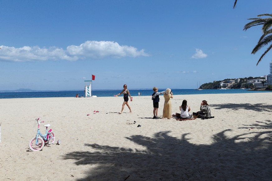 Am Son Matias-Strand in Palma de Mallorca entspannen sich ein paar Personen. 