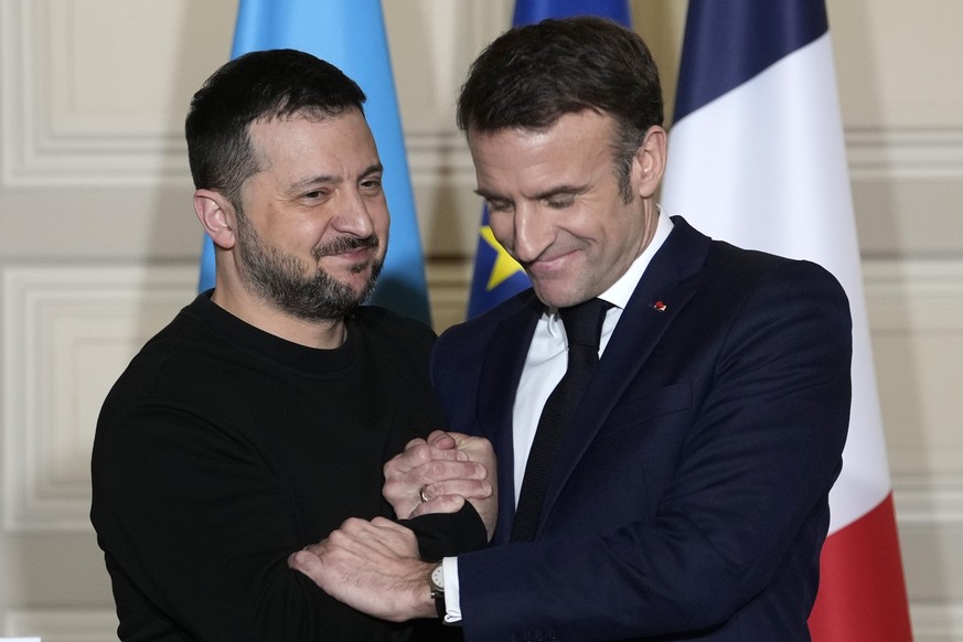 FILE - Ukrainian President Volodymyr Zelenskyy, left, and French President Emmanuel Macron shake hands after a press conference, on Feb. 16, 2024 at the Elysee Palace in Paris. More than 20 European h ...