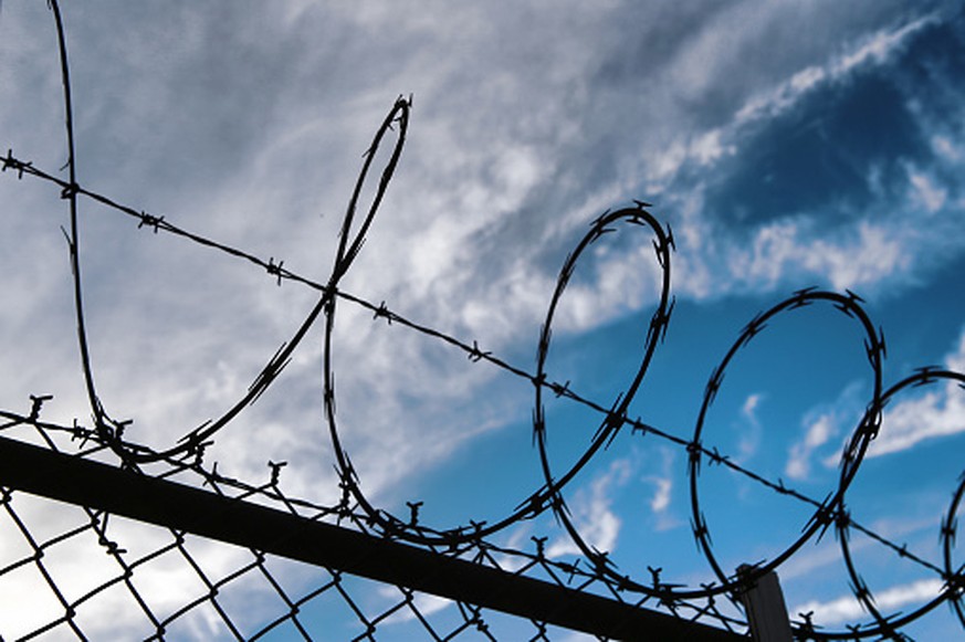 Barbed wire on top of chainlink fence. New York City, USA