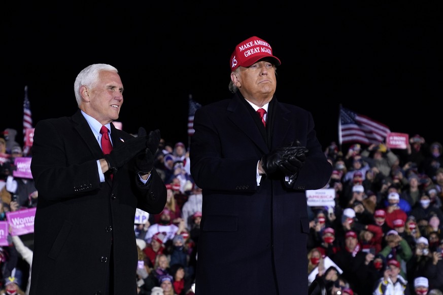 President Donald Trump and Vice President Mike Pence stand on stage after a campaign rally at Gerald R. Ford International Airport, early Tuesday, Nov. 3, 2020, in Grand Rapids, Mich. (AP Photo/Evan V ...