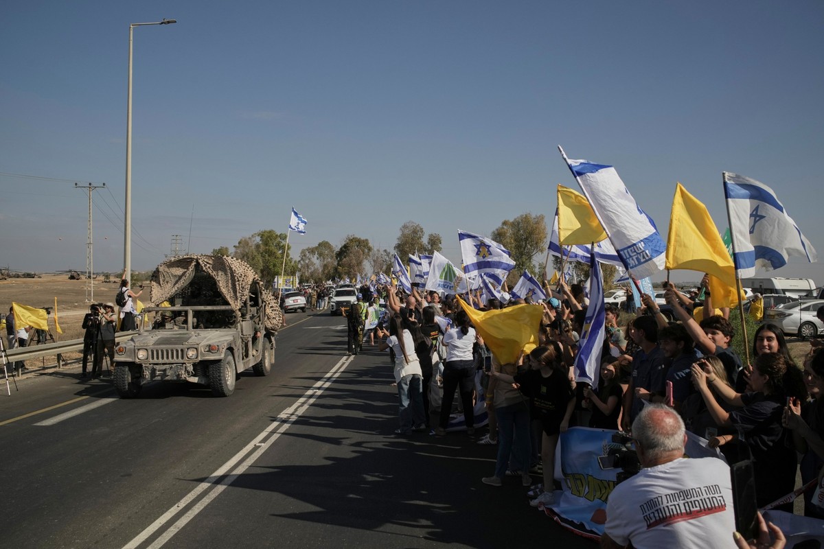 13.10.2025, Israel, Kibbuz Reim: Menschen reagieren, als ein Konvoi mit den aus dem Gazastreifen freigelassenen Geiseln auf einem Militärstützpunkt in der Nähe von Reim im Süden Israels eintrifft. Fot ...