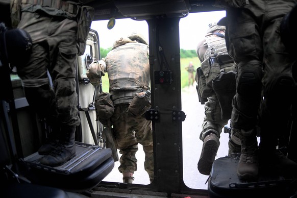Ukrainische Soldaten stürmen aus einem Transporter.