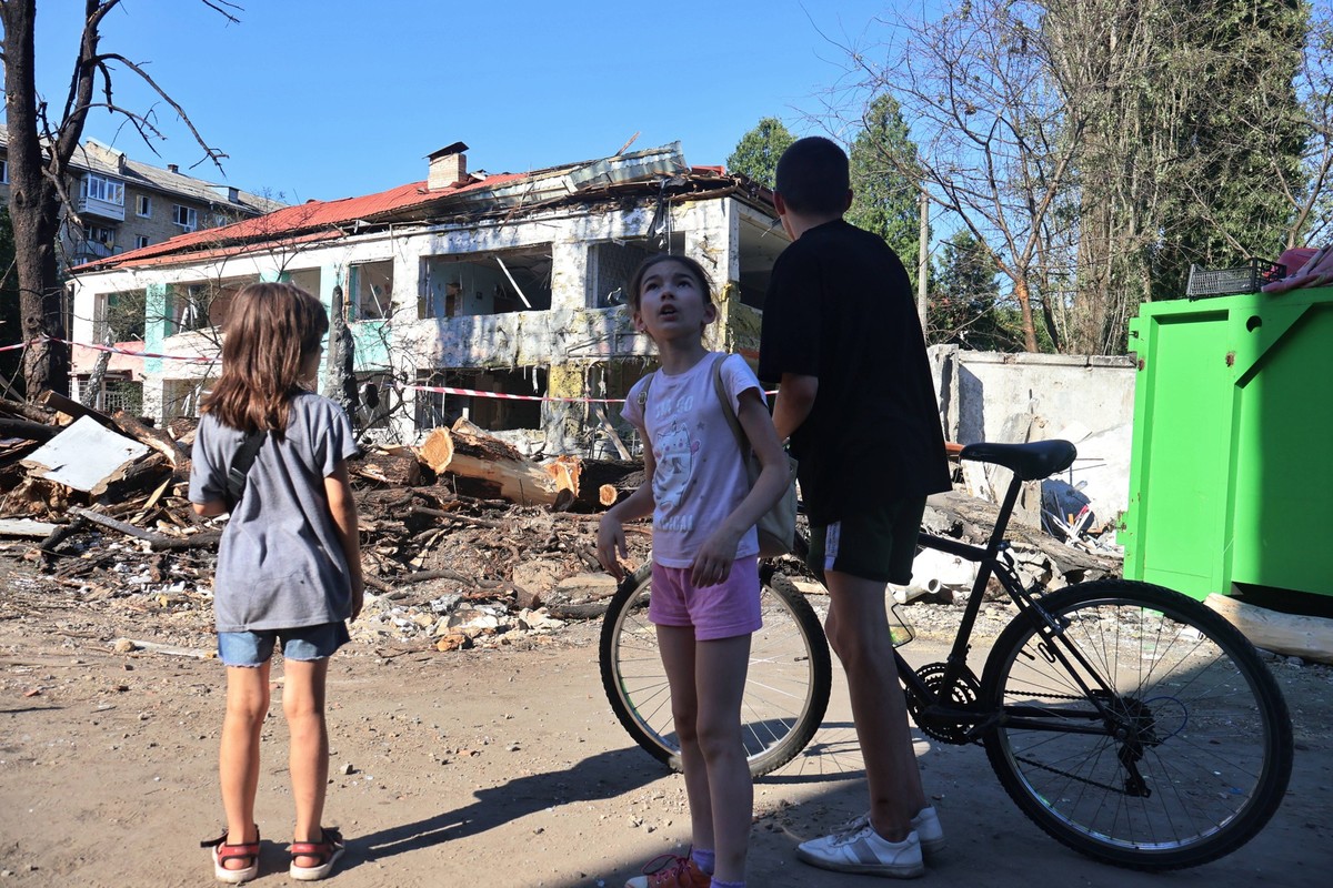 Aftermath of Russian missile attack in Kyiv s Holosiivskyi district - 09 Jul 2024 Children stand against the backdrop of a destroyed kindergarten and a destroyed five-story residential building in the ...