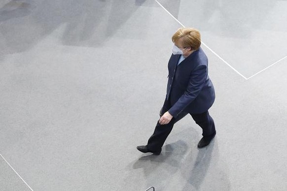 BERLIN, GERMANY - DECEMBER 16: German Chancellor Angela Merkel leaves after answering questions posed by parliamentarians at the Bundestag during the second wave of the coronavirus pandemic on Decembe ...