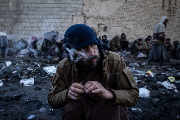 14.11.2022, Afghanistan, Kabul: Afghanische M�nner konsumieren Drogen auf einer Stra�e in Kabul. Drogensucht ist in Afghanistan, dem weltweit gr��ten Opium- und Heroinproduzenten und inzwischen auch e ...