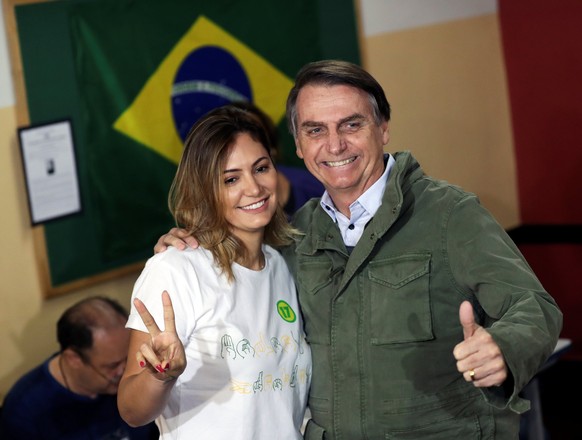 Jair Bolsonaro, far-right lawmaker and presidential candidate of the Social Liberal Party (PSL), and his wife Michelle pose as they arrive to cast their votes, in Rio de Janeiro, Brazil October 28, 20 ...