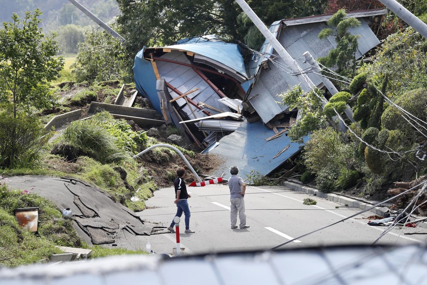 Buildings destroyed by a landslide block a road after an earthquake in Atsuma town, Hokkaido, northern Japan, Thursday, Sept. 6, 2018. Several people were reported missing in the nearby the town, wher ...