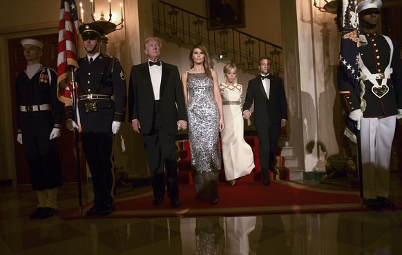 President Donald Trump, first lady Melania Trump, Brigitte Macron, and French President Emmanuel Macron walk down the Grand Staircase to pose for a photo in Grand Foyer before a State Dinner at the Wh ...