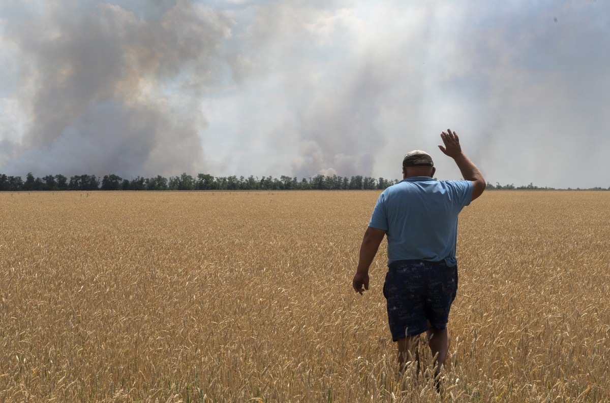 04.07.2022, Ukraine, Dnipropetrovsk: Ein Landwirt reagiert, als er auf sein brennendes Feld blickt, verursacht durch die K�mpfe an der Frontlinie in der Region Dnipropetrowsk. Sch�tzungsweise 22 Milli ...