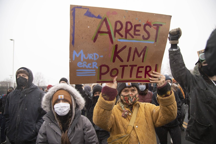 April 13, 2021, Brooklyn Center, Minnesota, USA: A person holds a sign that says arrest Kim Potter during a march to the Brooklyn Center Police Department. Protests continue over the police killing of ...