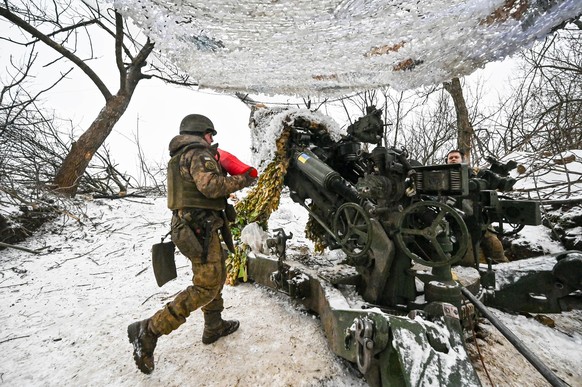 14.01.2024, Ukraine, Saporischschja: Soldaten des 66. separaten Kanonenartilleriebataillons der 406. separaten Artilleriebrigade der ukrainischen Streitkräfte mit der amerikanischen Haubitze M777 nahe ...