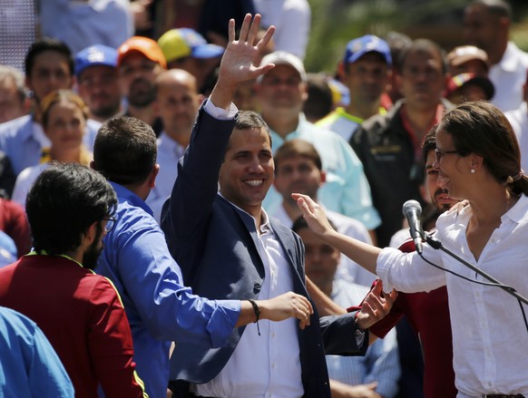 Venezuelan opposition leader Juan Guaido, center, who has declared himself the interim president of Venezuela, greets supporters as he arrives at a nationwide demonstration demanding the resignation o ...