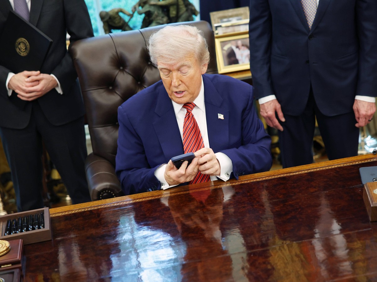 United States President Donald J Trump checks his phone as he signs executive orders regarding nuclear energy in the Oval Office of the White House in Washington, DC, US, on May 23, 2025. Trump signed ...