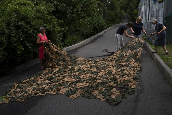26.07.2023, Ukraine, Kiew: Frauen arbeiten an einem Tarnnetz, um es an die Front zu bringen. Foto: Jae C. Hong/AP/dpa +++ dpa-Bildfunk +++