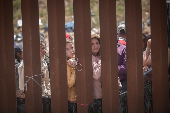 ARCHIV - 10.05.2023, Mexiko, Tijuana: Frauen stehen hinter der Grenzmauer zwischen Mexiko und USA und hoffen darauf, in die USA einreisen zu können. (zu dpa: «US-Grenzschutz in Texas warnt Migranten v ...