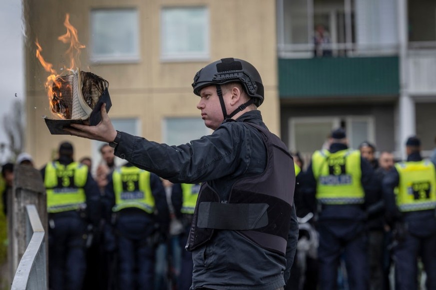 STOCKHOLM, SWEDEN - MAY 14: Rasmus Paludan burns a Koran during an election meeting in Husby on May 14, 2022 in Stockholm, Sweden. Far-right Danis-Swedish politican Rasmus Paludan, a controversial fig ...