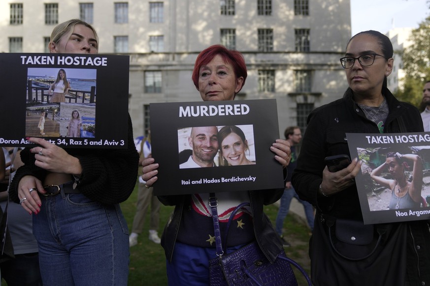 Women hold up photos during the &#039;Jewish Community Vigil&#039; for Israel, in London, Monday, Oct. 9, 2023, two days after Hamas fighters launched an unprecedented, multi-front attack on Israel wh ...