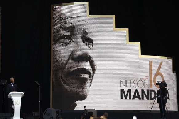Former U.S. President Barack Obama, left, delivers his speech at the 16th Annual Nelson Mandela Lecture at the Wanderers Stadium in Johannesburg, South Africa, Tuesday, July 17, 2018. In his highest-p ...