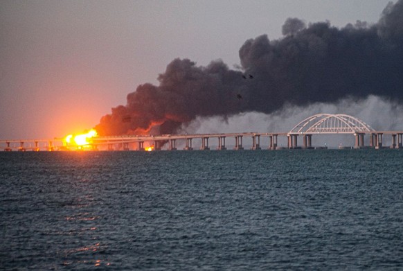 dpatopbilder - 08.10.2022, ---, Kertsch: Flammen und Rauch steigen von der Krim-Brücke auf, die das russische Festland und die Halbinsel Krim über die Straße von Kertsch verbindet. Die Explosion an de ...