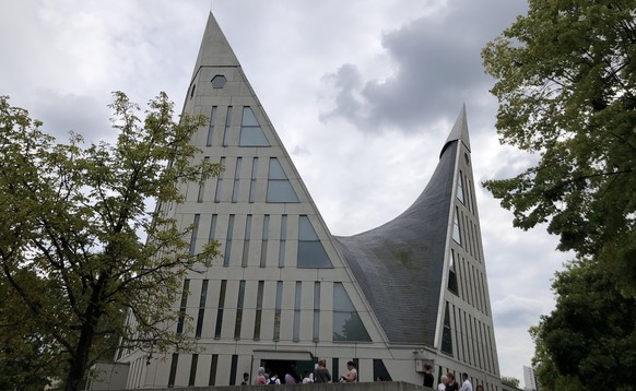 Etliche Menschen warten vor der Dreieinigkeitskirche in der Gropiusstadt auf ihren Zeitslot für die Essensausgabe.