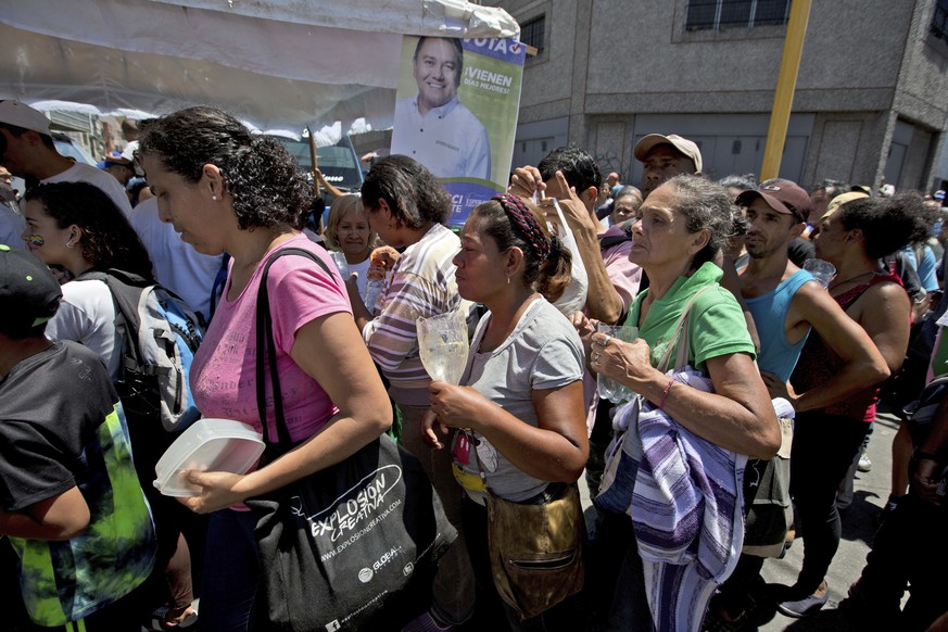 In this May 12, 2018 photo, people stand in line for a free serving of soup at a campaign rally hosted by presidential candidate Javier Bertucci, in Caracas, Venezuela. (AP Photo/Fernando Llano) |