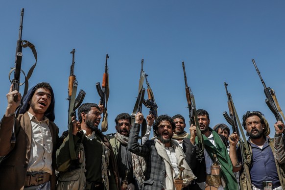 29.01.2024, Jemen, Sanaa: Bewaffnete Mitglieder der vom Iran unterstützten Huthi-Miliz nehmen an einer Demonstration gegen die USA und Israel teil. Die Spannungen zwischen den USA und den Huthi haben  ...