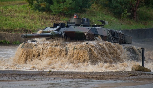 ARCHIV - 25.09.2017, Niedersachsen, Munster: Ein Kampfpanzer vom Typ �Leopard 2A6� f�hrt bei der Vorbereitung zu der Informationslehr�bung �Landoperationen 2017� durch ein Wasserbecken. Deutschland wi ...
