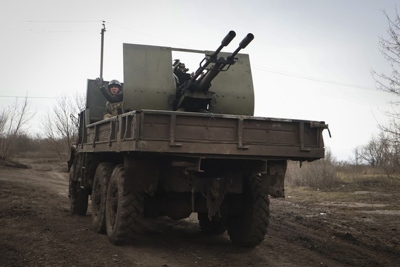 18.03.2023, Ukraine, Bachmut: Ein ukrainischer Soldat winkt in der Nähe von Bachmut von einem Militärfahrzeug. Foto: Roman Chop/AP +++ dpa-Bildfunk +++