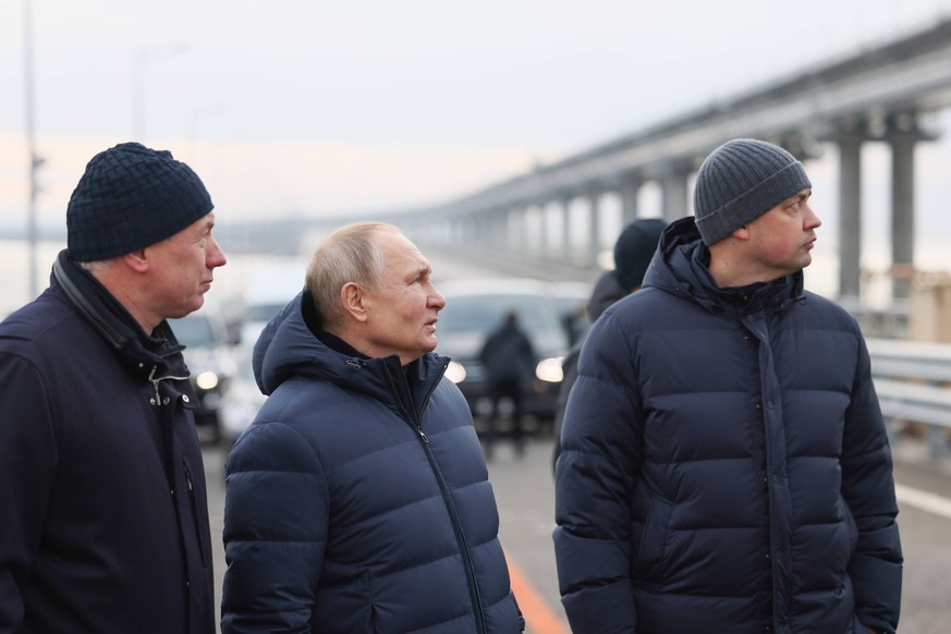 RUSSIA - DECEMBER 5, 2022: Russia s President Vladimir Putin C talks to engineer Nikita Khrapov R of the Taman Federal Road Agency Directorate Uprdor Taman and Russia s Deputy Prime Minister Marat Khu ...