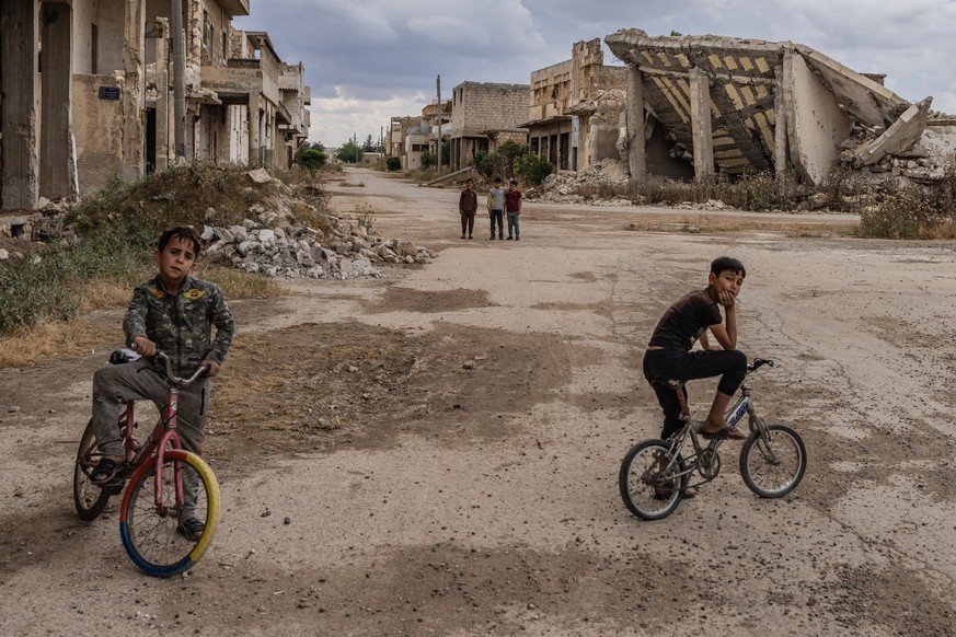 13.05.2024, Syrien, Aleppo: Kinder halten sich auf einem Platz auf, der durch den Krieg in der Stadt Tadef in Aleppo beschädigt wurde. Foto: Anas Alkharboutli/dpa +++ dpa-Bildfunk +++