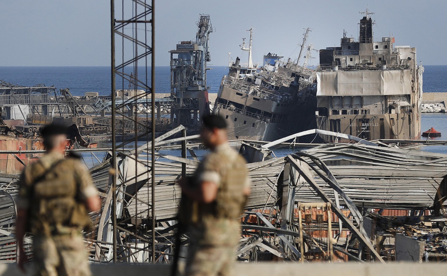 Lebanese army soldiers stand guard in front of destroyed ships at the scene where an explosion hit on Tuesday the seaport of Beirut, Lebanon, Thursday, Aug. 6, 2020. Lebanese army bulldozers plowed th ...