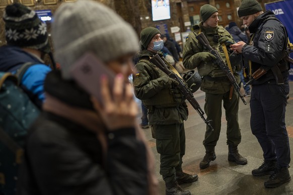 24.02.2022, Ukraine, Kiew: Ukrainische Soldaten stehen Wache am Bahnhof w�hrend Menschen versuchen die Stadt zu verlassen. Die russischen Truppen haben ihren erwarteten Angriff auf die Ukraine gestart ...