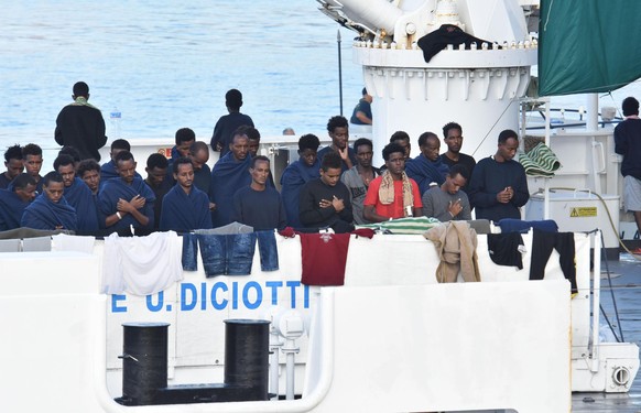 Migrants pray aboard the Italian Coast Guard ship &quot;Diciotti&quot; moored at the Catania harbor Wednesday, Aug. 22, 2018. The European Union is trying to find countries willing to take 177 people  ...