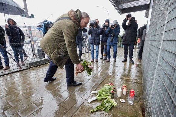 10.03.2023, Hamburg: Ein Mann legt vor dem Geb�ude der Zeugen Jehovas im Stadtteil Alsterdorf Blumen nieder. Bei einem Amoklauf w�hrend einer Veranstaltung der Zeugen Jehovas sind am Donnerstagabend m ...